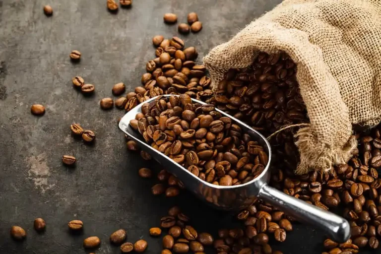 Green coffee beans in a burlap bag with scoop